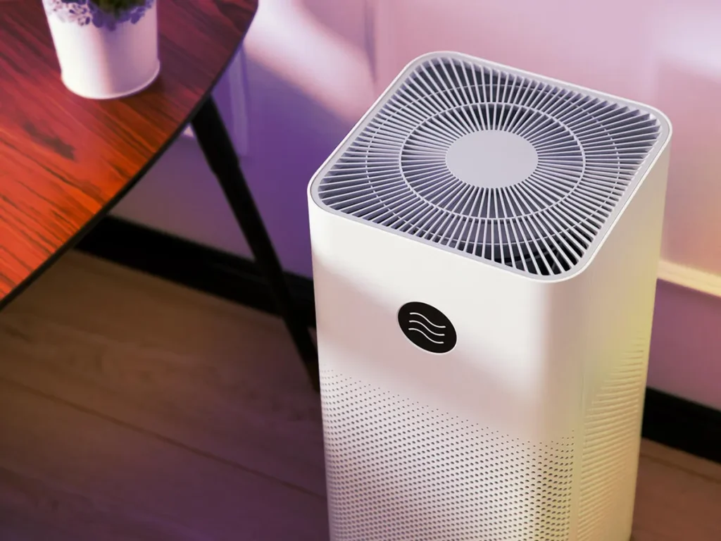Modern air purifier placed near a table, designed to improve indoor air quality by removing allergens and pollutants.