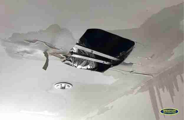 Ceiling with a large hole and visible ductwork caused by severe water damage in a home near College Station, TX.