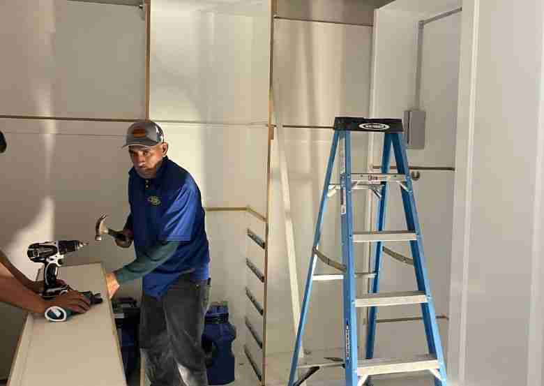 Local water restoration company in Houston TX repairing damaged drywall and cabinetry after water damage.
