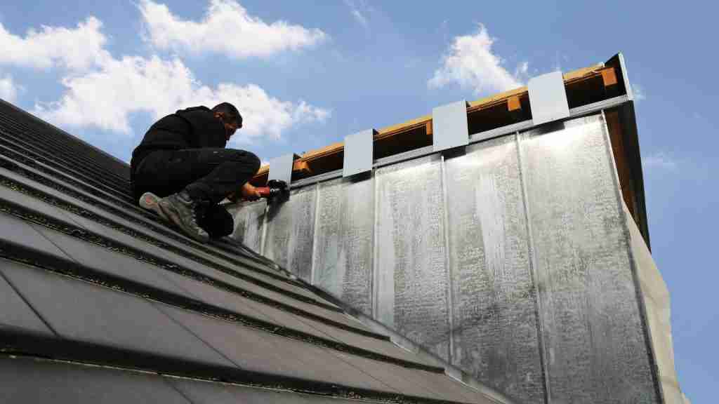 Anderson Restoration crew member inspecting a residential roof with a clipboard and measuring tools, Houston suburb in the background