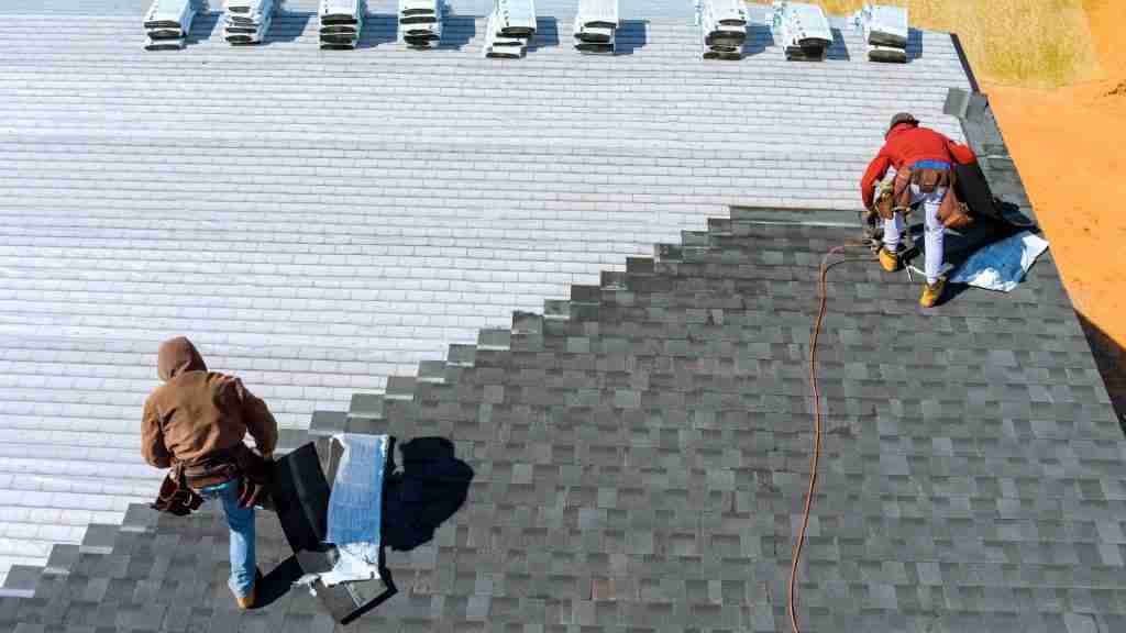 Anderson Restoration crew mid-installation on a residential roof replacement, with old shingles removed and new underlayment visible