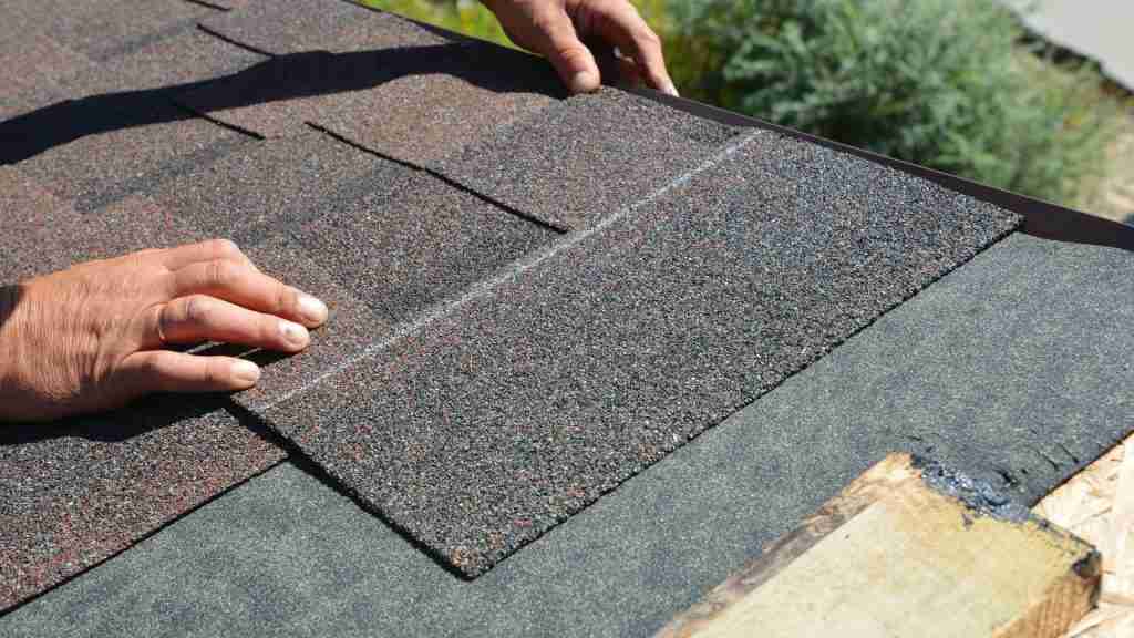 Close-up of hail-damaged asphalt shingles on a Houston-area residential roof, showing cracked and missing granules