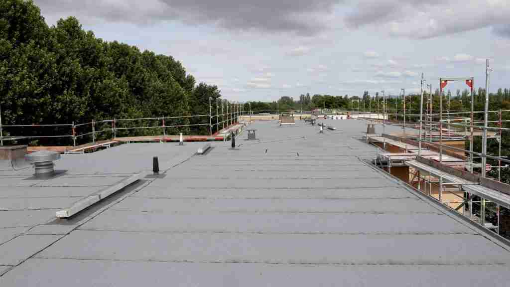 Ponding water visible on a flat commercial roof surface in Houston, with a ruler showing depth of standing water