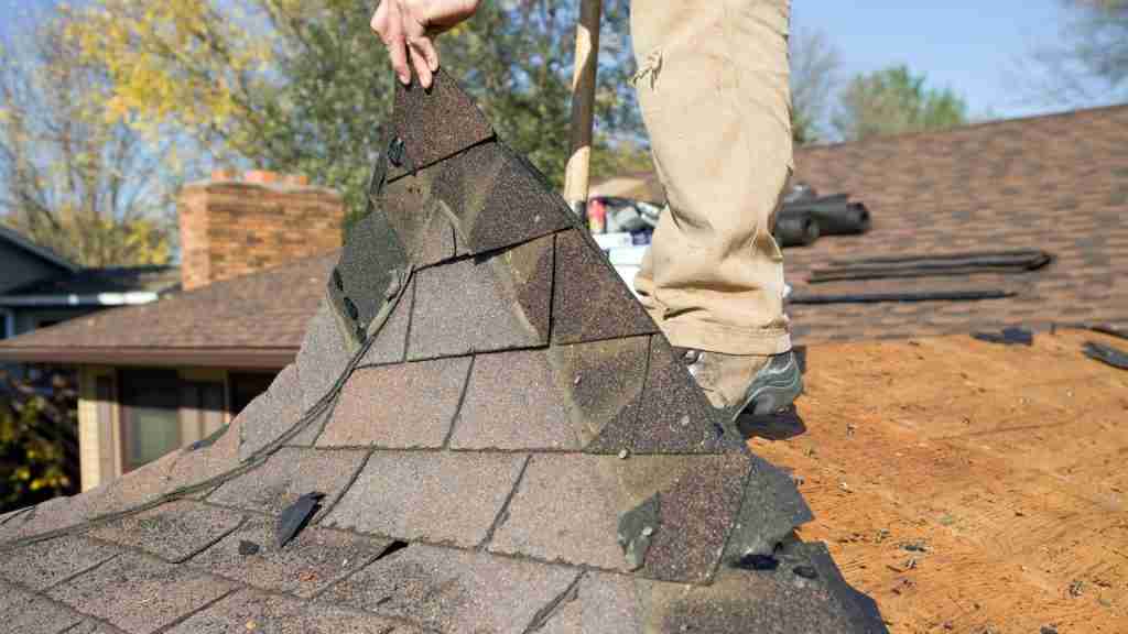 Residential roof in a Houston suburb showing wind-lifted shingle tabs after a severe thunderstorm