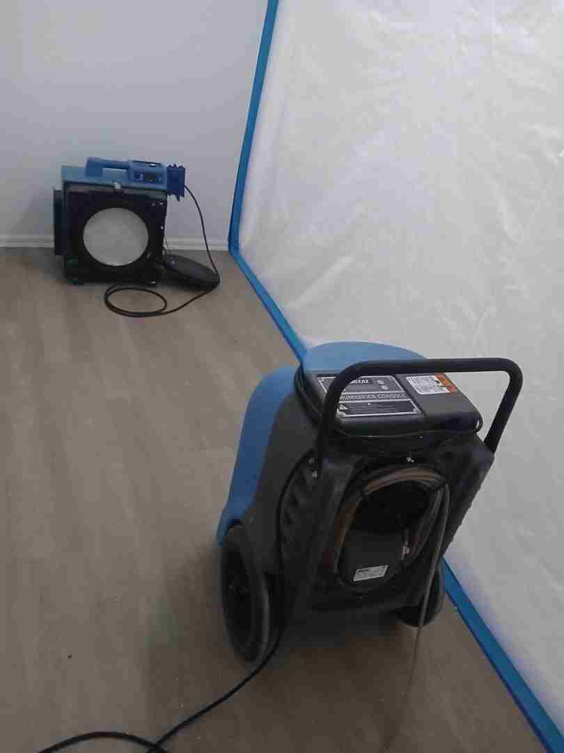 Dehumidifier and HEPA air scrubber running inside containment zone during active mold remediation