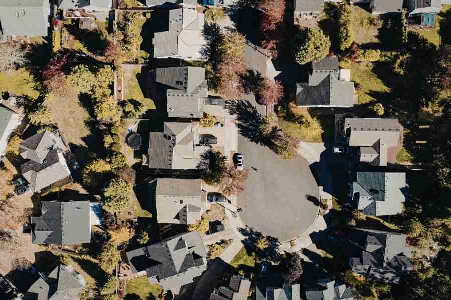 Aerial view of a tree-covered suburban neighborhood with a heavy canopy shading the homes and yards below.