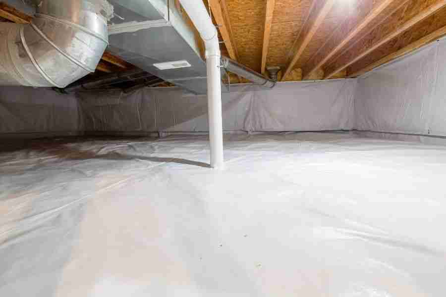 Encapsulated crawl space with white vapor barrier on the floor and walls beneath a Texas home.