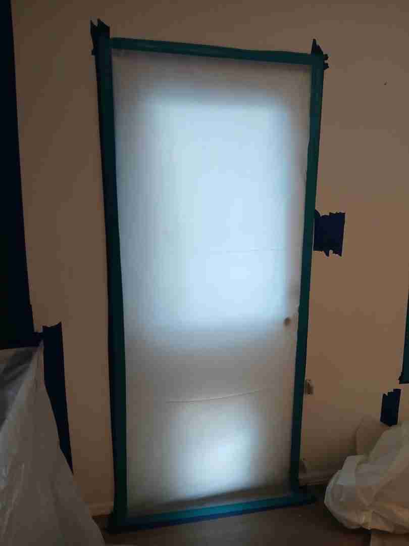 Sealed containment doorway with blue tape barrier protecting unaffected areas during mold remediation