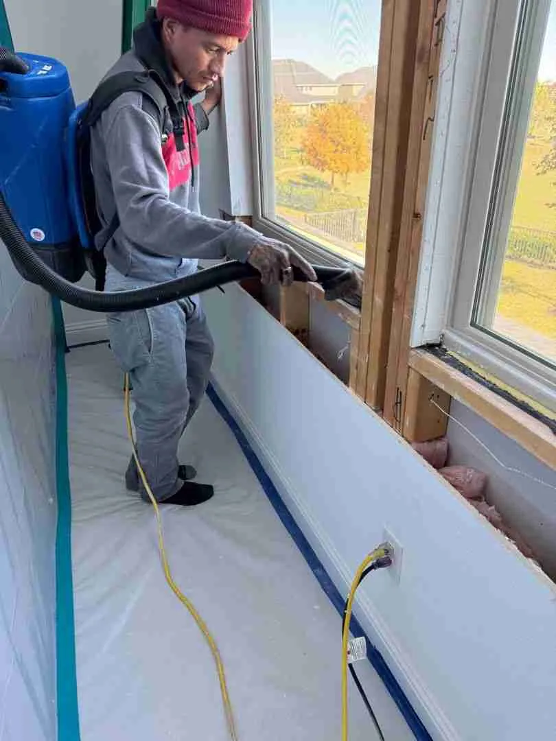 HEPA backpack vacuum cleaning exposed window framing during a Houston mold remediation job