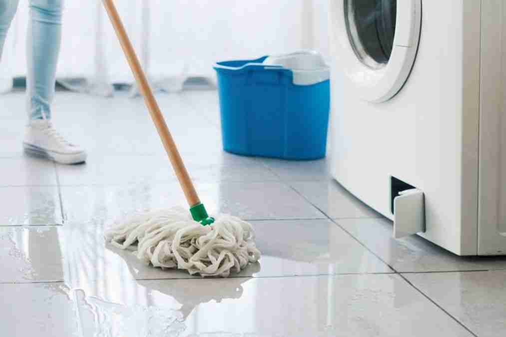 Water pooling on a laundry room floor near a washing machine in a Sugar Land home