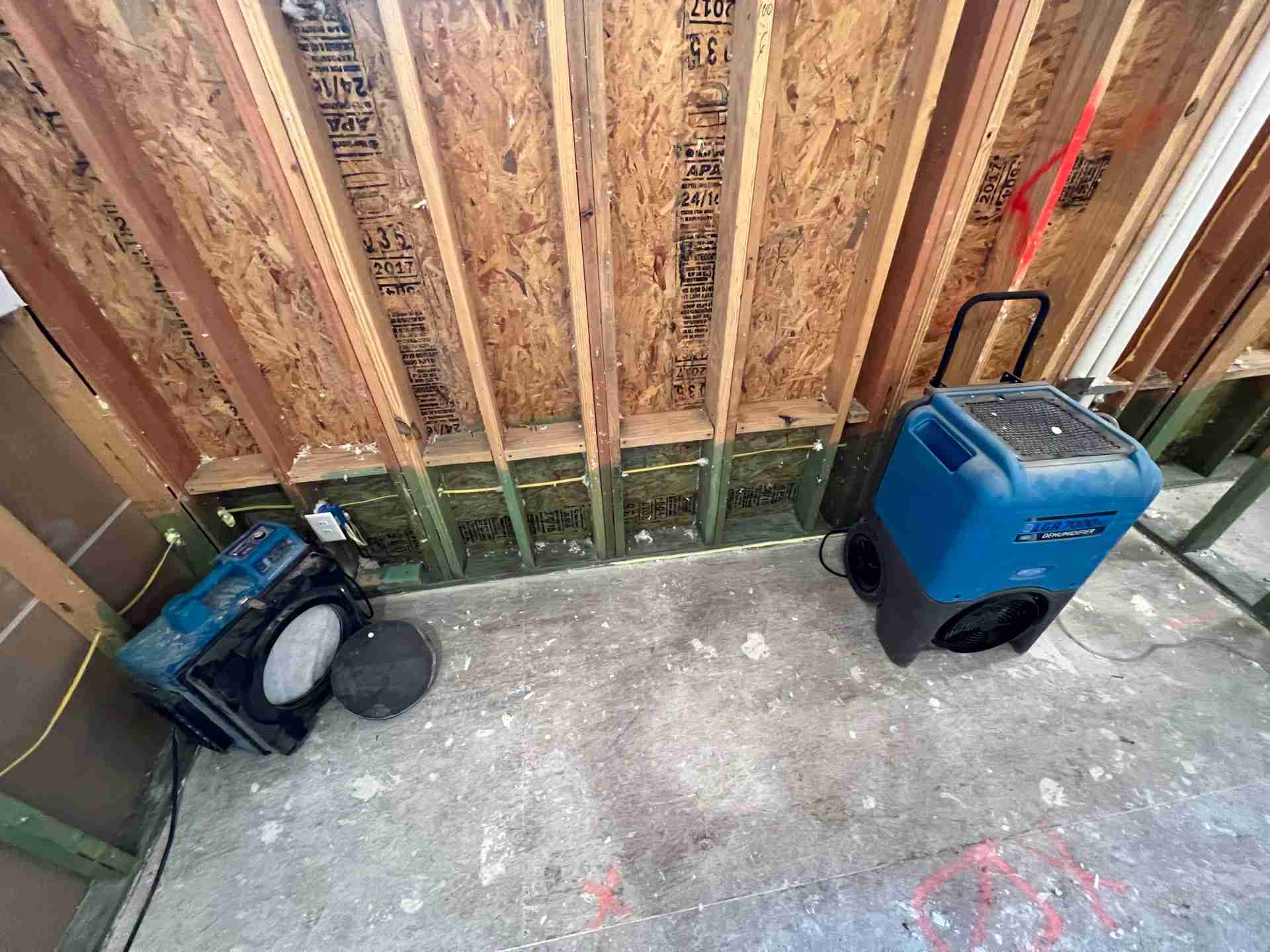 Structural drying equipment including dehumidifiers and air movers set in place after demolition