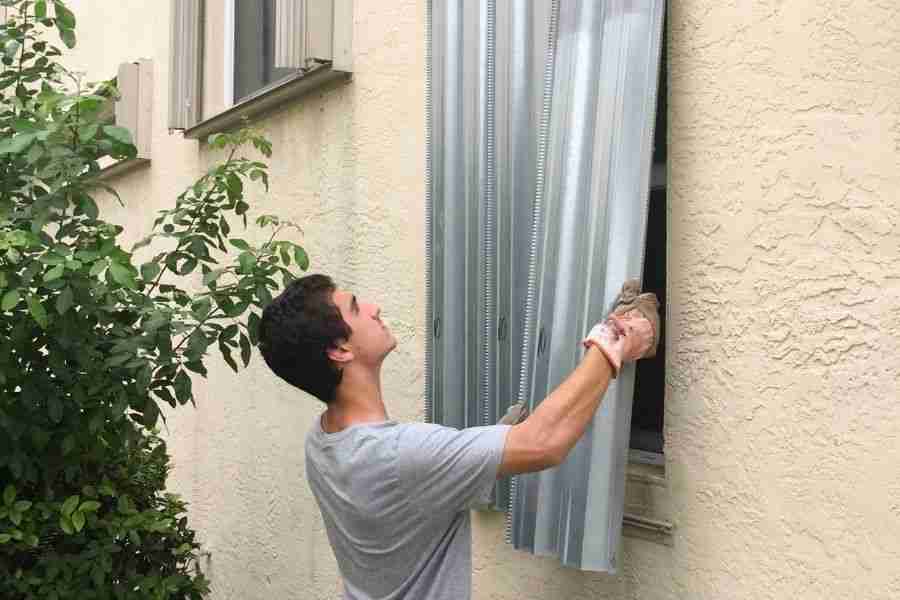 Homeowner preparing a Cypress, TX home for hurricane season by checking window and door seals