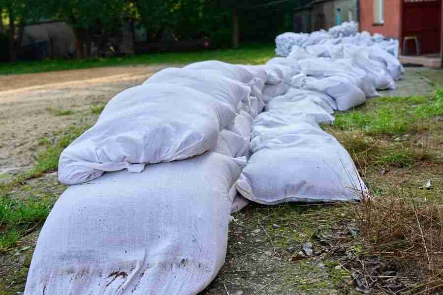 White sandbags lined up as a flood barrier along a home's edge in Cypress TX