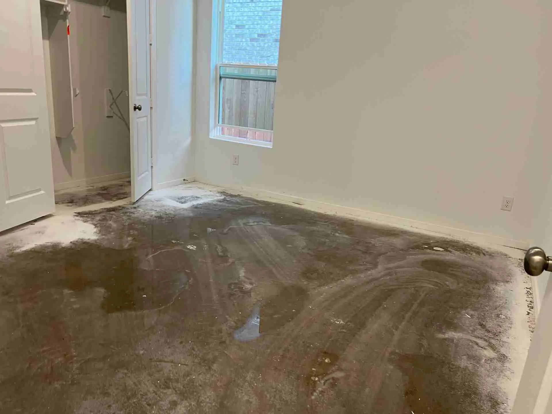 Water and silt spread across a bedroom slab on the first floor of a Fulshear TX home