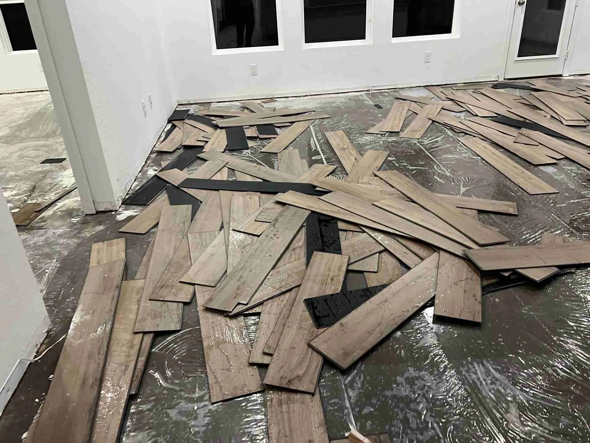 Water damaged plank flooring removed down to the slab in a Fulshear TX home