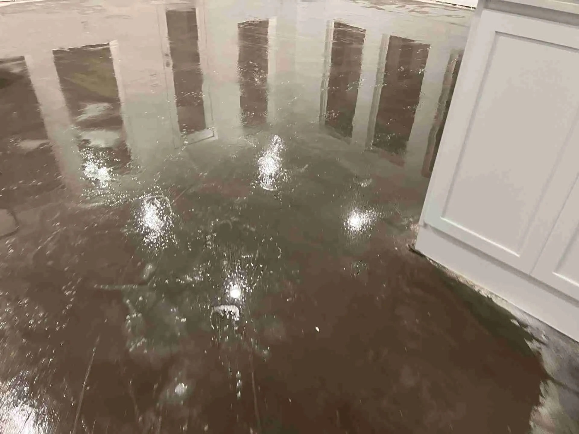 Standing water on an exposed kitchen slab after flooring removal in a Fulshear TX water damage job
